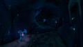A corridor leading to a dark cave within a blue ice cave