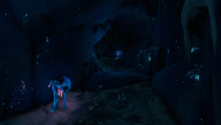 A corridor leading to a dark cave within a blue ice cave